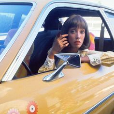 a woman sitting in the driver's seat of a car