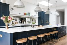 a large kitchen with blue cabinets and stools