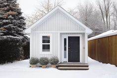 a small white house sitting in the snow