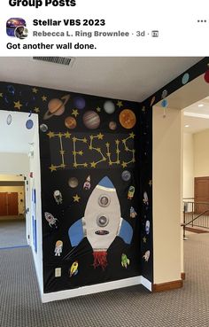 a space themed wall in an empty room with lots of decorations on the walls and around it