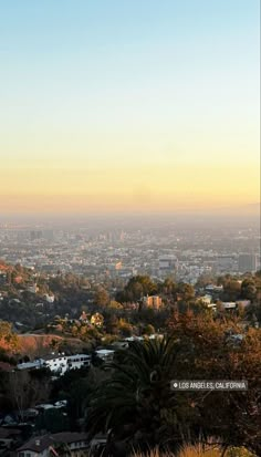 a view of the city from atop a hill with trees and buildings in the background