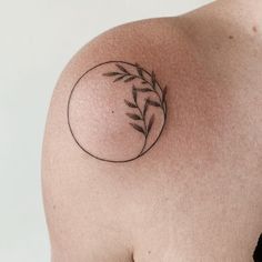 a close up of a person's shoulder with a small tattoo on the top