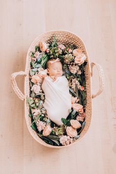 an overhead view of a baby in a basket with flowers