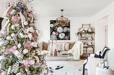 a decorated christmas tree in the middle of a living room with white and black decorations