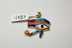 "Egyptian carving Handmade Colored Eye Of Horus 18K Yellow Gold Pendant 3.5 Gr Weight Approximate : 3.5 Gr Height : 1.2\" = 31 mm Width : 1\" = 27 mm ✔ IT IS Tested & SIGNED WITH THE EGYPTIAN Gold Government HALLMARK FOR 18K GOLD to Ensure Authenticity. ✔ Lovely gift idea ABSOLUTELY GORGEOUS, LOOKS FABULOUS ON. ✔ 100% Egyptian handmade. ✔ Condition: A brand-new, exactly as on the photos. ★ GIFTS ✔ All items are packaged in a paper jewelry gift box, ready for gifting. ✔ If you are sending a g Gold Plated Evil Eye Symbolic Jewelry, Symbolic Gold Plated Evil Eye Jewelry, Gold Evil Eye Amulet Jewelry, Symbolic Pendant With Diamond Eyes, Gold Plated Evil Eye Amulet Jewelry, Gold Spiritual Jewelry With Evil Eye, Brass Evil Eye Jewelry As A Gift, Brass Evil Eye Jewelry For Gifts, Spiritual Evil Eye Pendant Jewelry