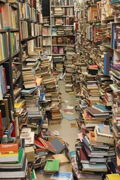 a large amount of books are stacked on the floor