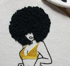 an embroidery project with a woman's torso and afro hair on the back of it