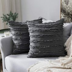 two gray pillows sitting on top of a couch