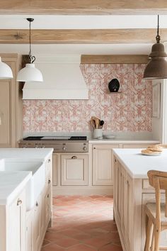 a kitchen with pink and white wallpaper, wooden cabinets and an island in the middle