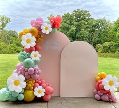 an arch decorated with flowers and balloons