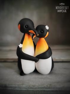 two small black and white penguins sitting next to each other