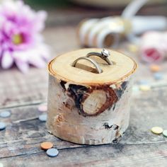 two wedding rings sitting on top of a piece of wood