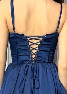 the back of a woman's blue dress with laces on it and an open neckline