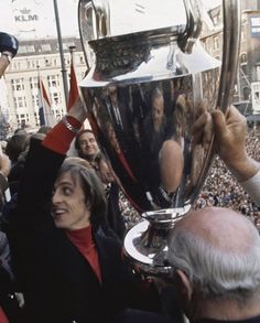 a woman holding up a trophy in front of a crowd