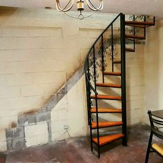 an empty room with a spiral staircase and table