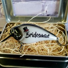 a white and black fishing lure in a box