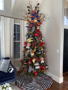 a decorated christmas tree in the corner of a living room with black and white checkered rugs