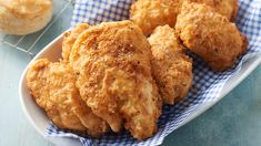 some fried food is on a plate with a blue and white checkered napkin next to it