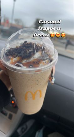 a person holding up a plastic cup with food in it and the words caramel frappe u oreos