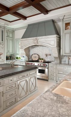 a large kitchen with white cabinets and marble counter tops