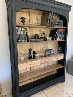 a bookcase with many books and figurines on it