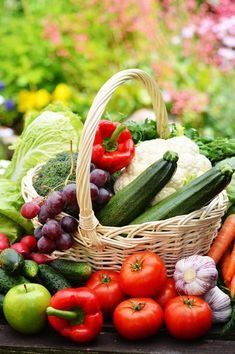 a basket filled with lots of different types of vegetables next to other fruits and vegetables