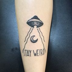 a tattoo on the leg of a person with a hat and an alien flying over their head