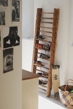 an old ladder leaning against the wall in a room with pictures and baskets on it