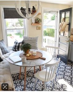 a living room filled with furniture and a white table in front of a window on top of a tiled floor