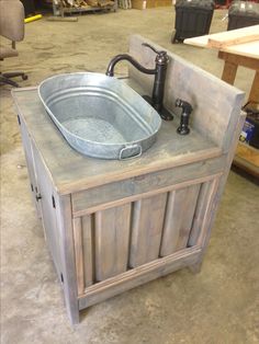 a metal sink sitting on top of a wooden cabinet