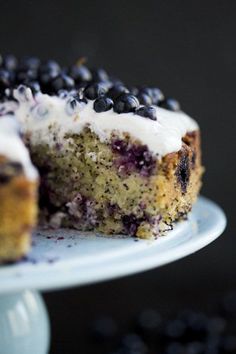 a blueberry cake on a plate with one slice cut out