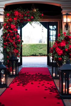 a red carpeted walkway with lanterns and roses on each side, leading to an entrance