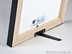 a close up of a wooden frame with a black handle