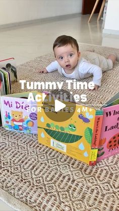 a baby is laying on the floor in front of several children's books and reading them