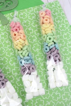 two bags filled with marshmallows sitting on top of a green tablecloth