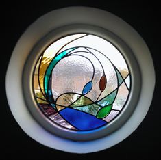 a round stained glass window in a dark room