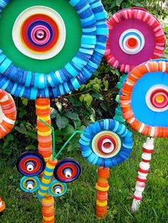 an assortment of colorful paper flowers in the grass