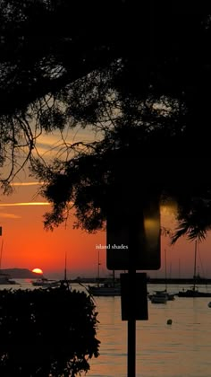 the sun is setting over the water and boats are out on the water in the distance