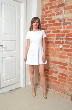 Step into timeless elegance with this vintage 80s white short sleeve dress. Featuring a flared silhouette that flatters the figure, this dress is adorned with subtle embellishments that add a touch of sparkle and sophistication. The convenient pocket adds a practical yet stylish detail, making this dress both beautiful and functional. Sized small, it offers a comfortable fit perfect for various occasions. In excellent vintage condition, this dress captures the classic charm and understated glamo White Fitted Mini Dress With Cap Sleeves, Fitted White Mini Dress With Cap Sleeves, White Short Sleeve Mini Dress For Formal Occasions, White Fitted Knee-length Short Sleeve Dress, White Vintage A-line Mini Dress, White Short Sleeve Mini Dress For Work, White Fitted Short Sleeve Elegant Dress, Elegant White Fitted Short Sleeve Dress, White Short Sleeve Dress