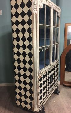 an old fashioned cabinet with black and white checkered tiles on it's sides