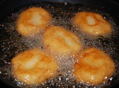 fried food being cooked in a frying pan on top of a stovetop burner