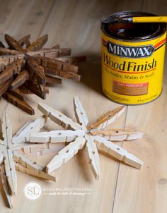 some wood sticks are laying on the floor next to a paint can and a snowflake