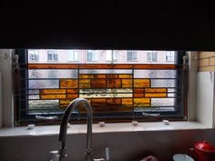 a kitchen sink under a stained glass window