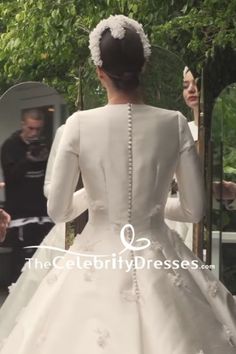 a woman in a white wedding dress standing next to a man