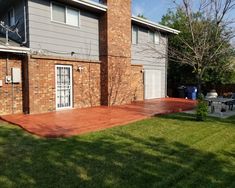 a brick house with an attached patio in the back yard