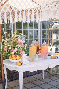 a table topped with lots of food and drinks next to a window filled with flowers