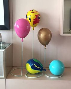 three balloons are sitting on top of each other in front of a television screen and some wire