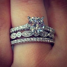 a close up of a person's hand with two wedding rings