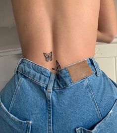 a woman with a butterfly tattoo on her lower back and the bottom part of her stomach