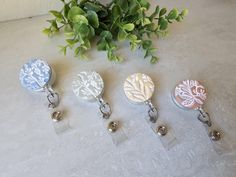 Neutral floral clay badge reels. Nice piece for your work wardrobe. Handmade with polymer clay and white paint. Badge holders for nurses, healthcare workers, teachers, students, office workers and more. 1" in diameter. 30" retractable cord. Alligator or belt clip available on checkout. Polymer Clay Badge Reel, Polymer Clay Badge, Clay Badge Reel, Student Id, Handmade Personalized Gifts, Healthcare Workers, Teacher Student, Name Badges, Belt Clip